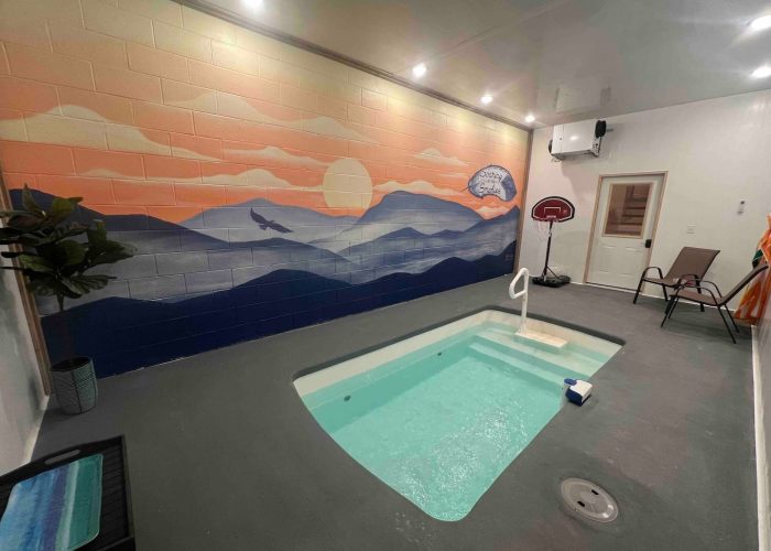 Indoor heated pool with a painted mural by a local artist